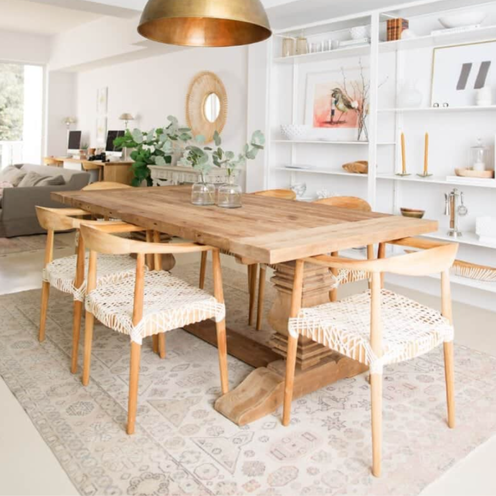 Reclaimed wood dining table and woven oak chairs under a brass pendant in the Calimia Home studio