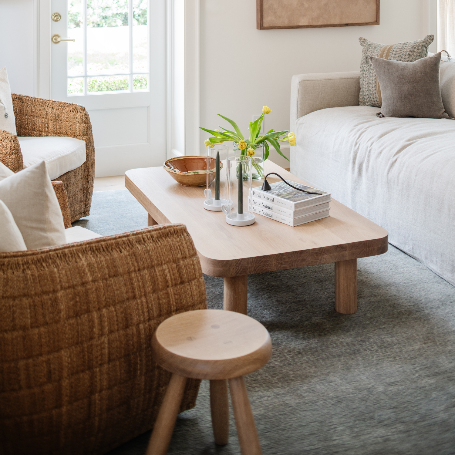 Living room with wooden coffee table, chairs, and a couch.