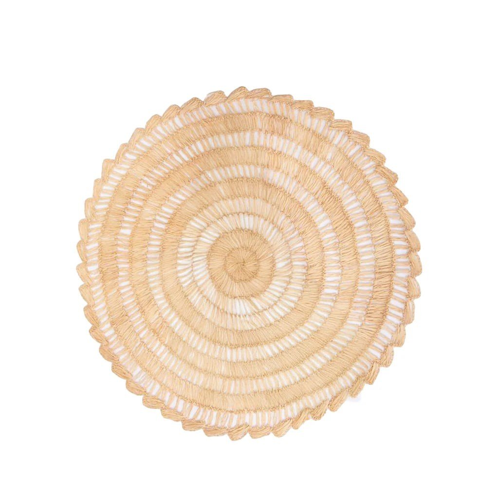 Calimia Home handwoven round Buriti palm fiber placemat in natural earthy tones with a scalloped edge.
