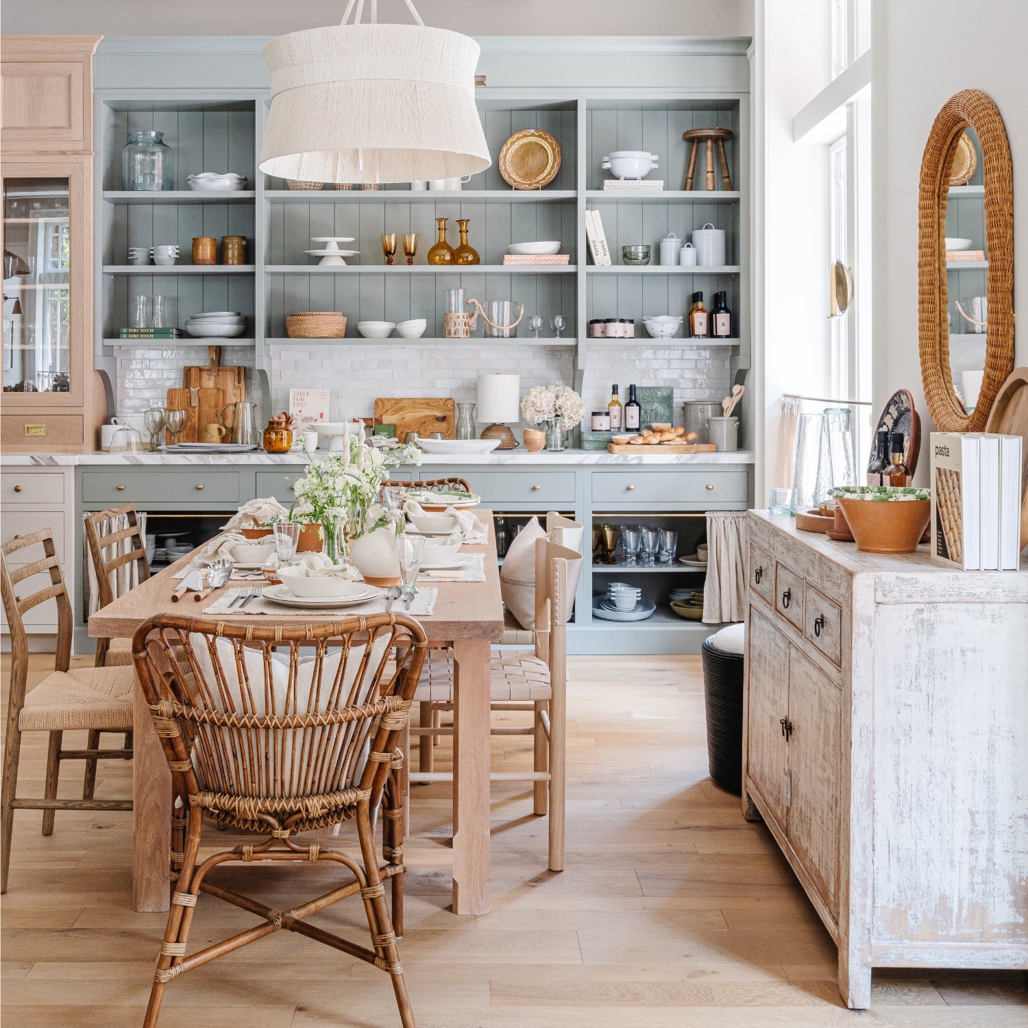 Styled dining area with rattan chairs and open shelving inside the Calimia Home shop