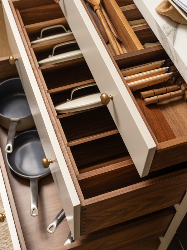 Walnut drawer organizers with peg dividers storing cookware in a custom Stoffer Home Cabinetry kitchen