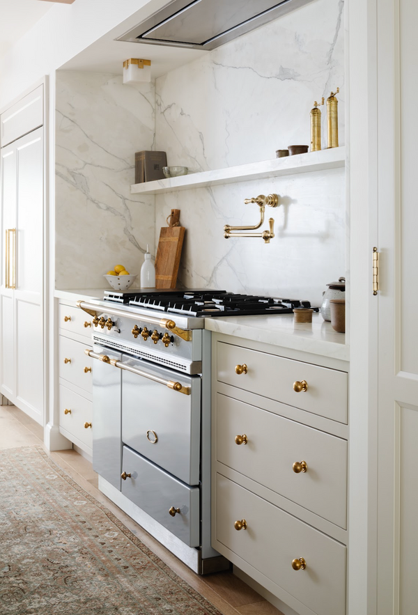 Stainless Lacanche range with brass pot filler and white custom cabinetry by Calimia Home