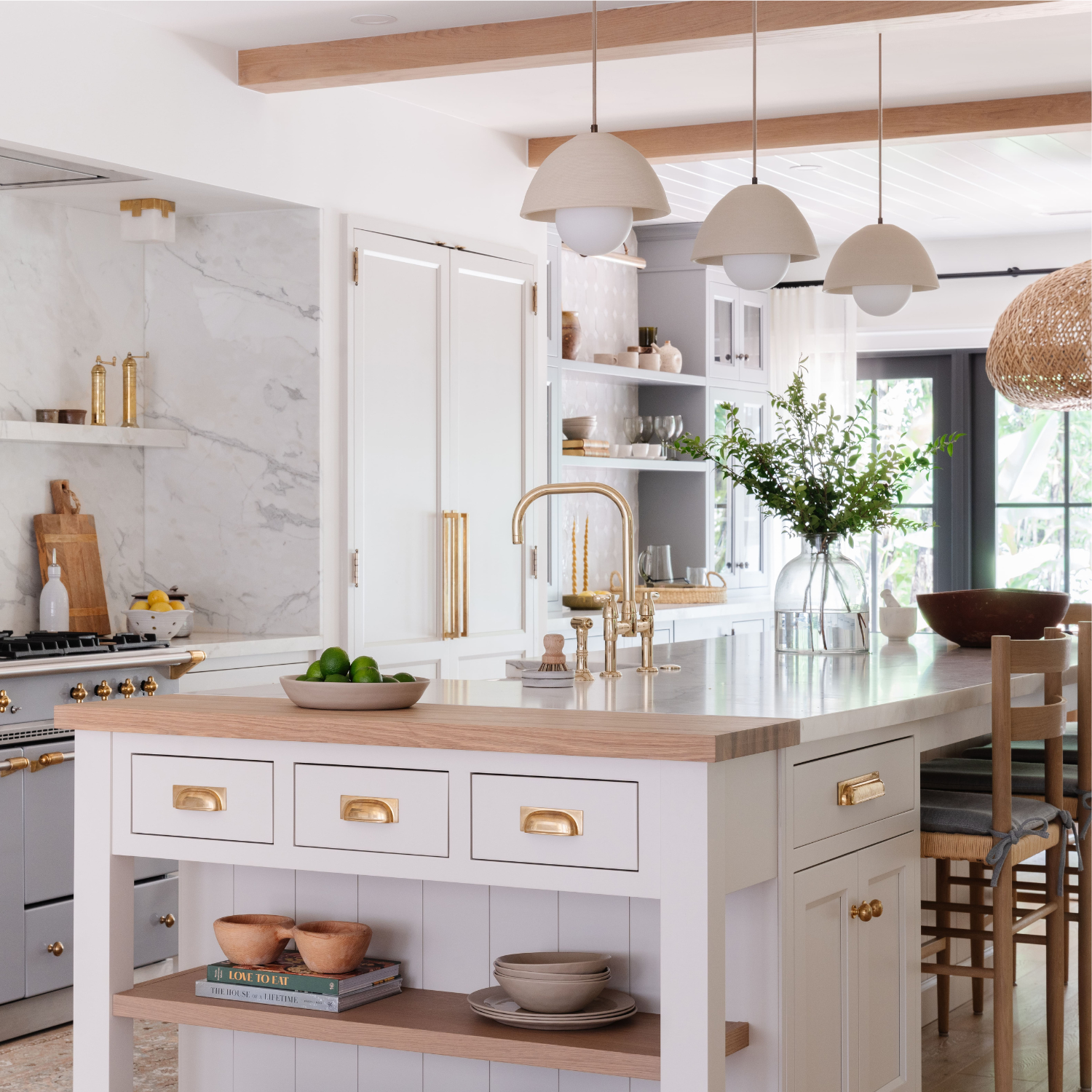 Custom white kitchen cabinetry with brass hardware and marble accents designed by Calimia Home
