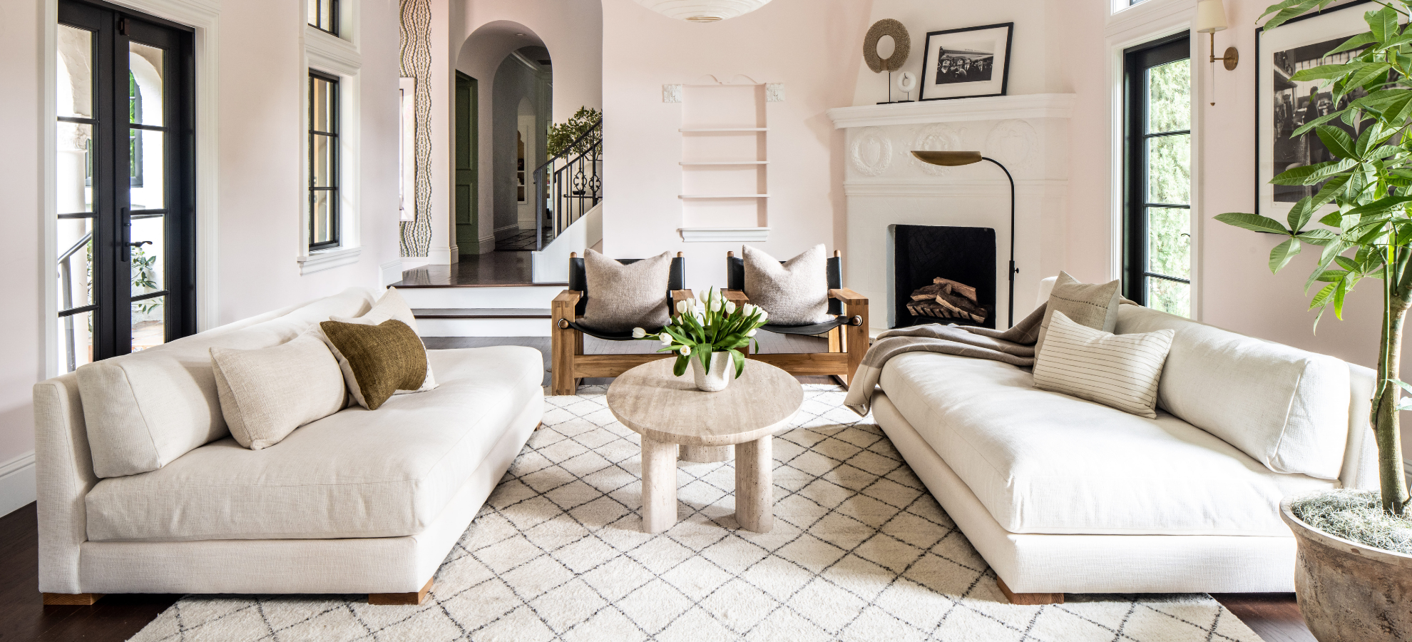 Bright living room with twin white sofas and fireplace styled by Calimia Home design studio in Coral Gables