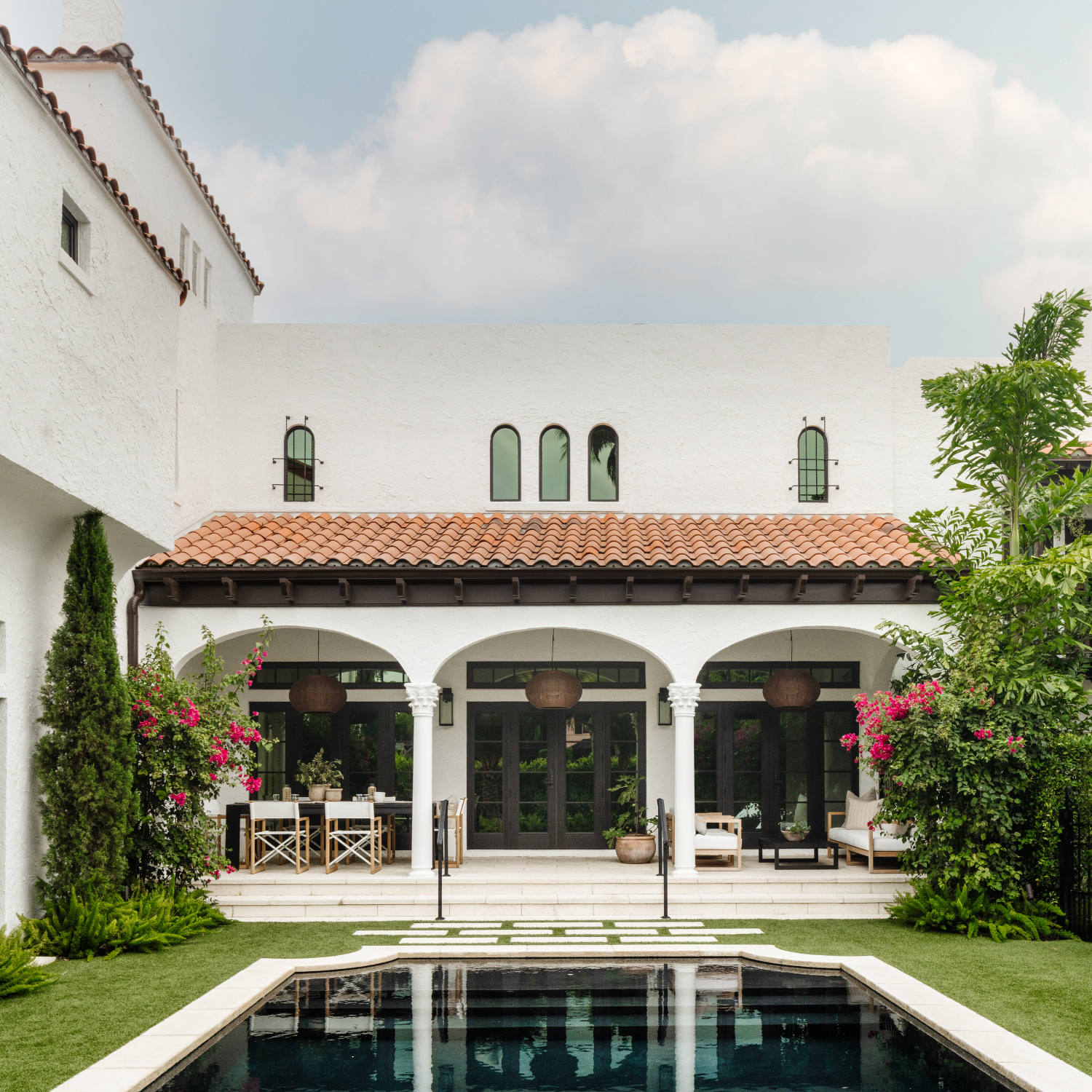 Spanish-style white villa with arched loggia, pool and bougainvillea from a Calimia Home project