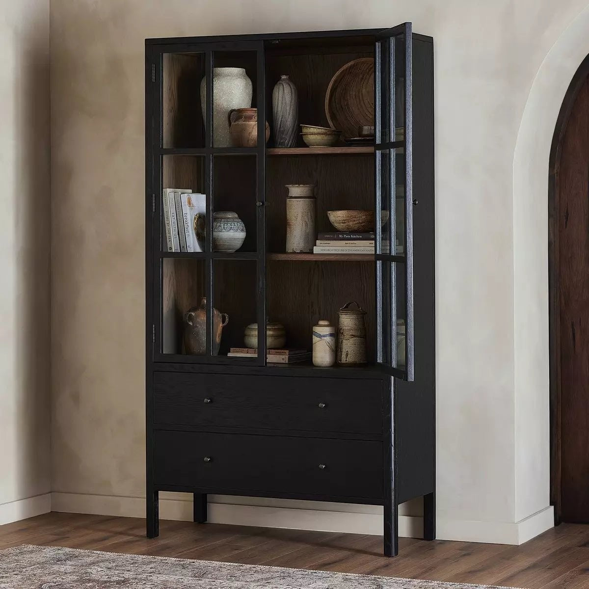 Calimia Home ebony oak cabinet with glass doors, two drawers, and tan oak interior shelving in a transitional style.