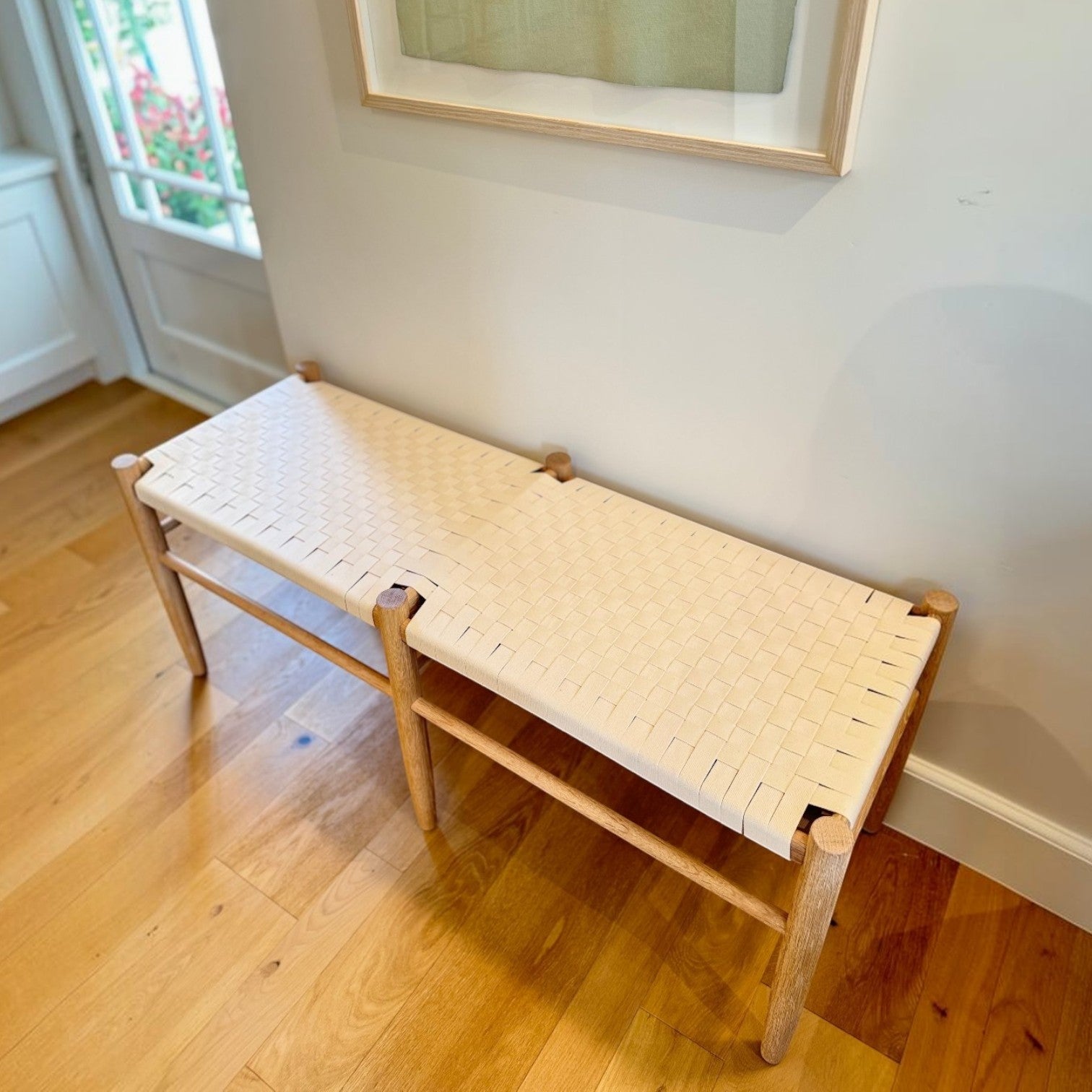Calimia Home Gaon bench featuring a solid white oak frame and a handwoven white canvas ribbon seat in a bright room.