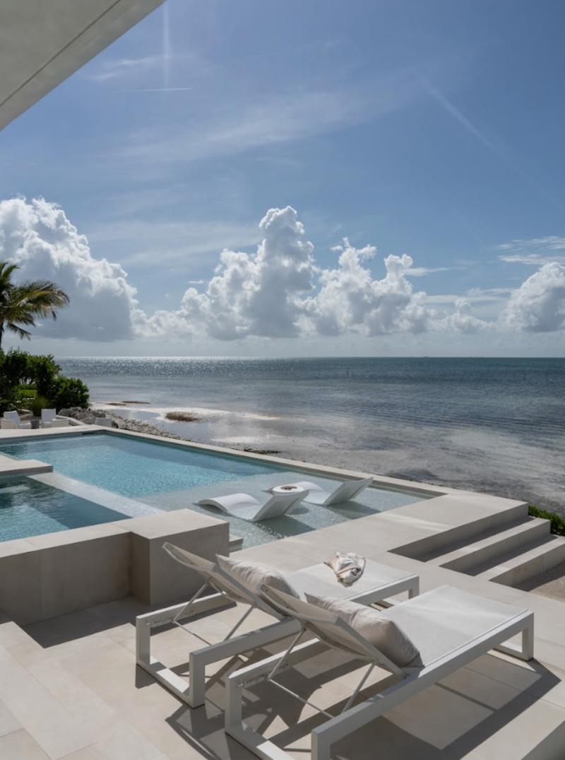 Infinity-edge pool with white loungers overlooking the Atlantic at the Peaceful Waters home, Islamorada