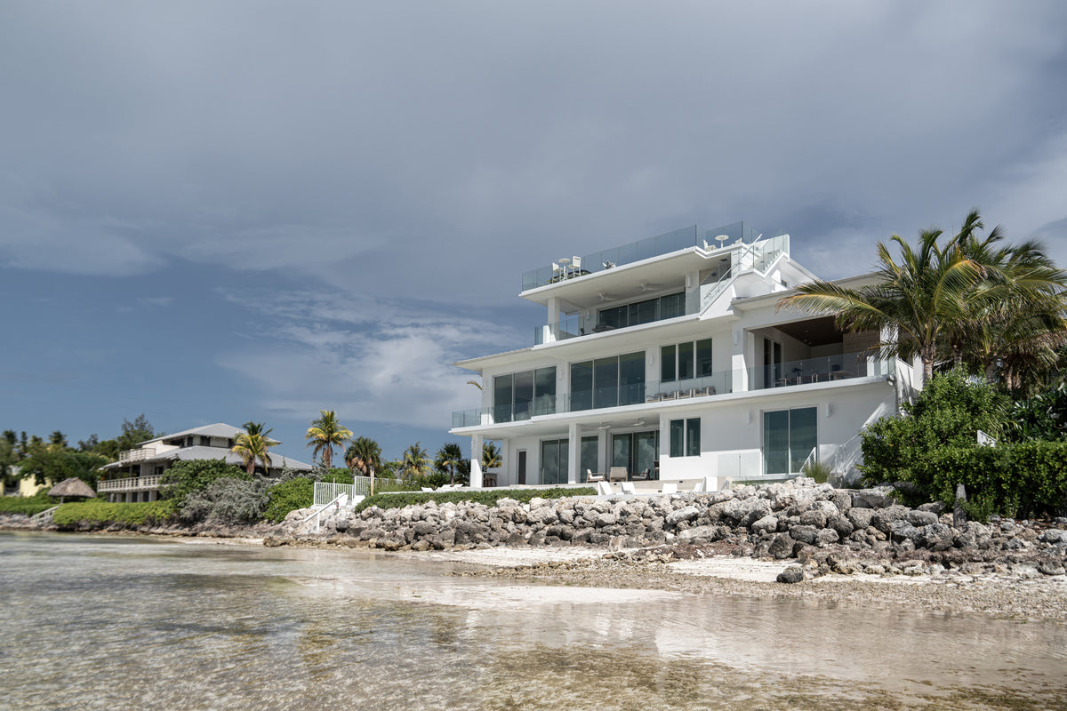 White modern three-story home on the Islamorada shoreline, the Peaceful Waters project by Calimia Home