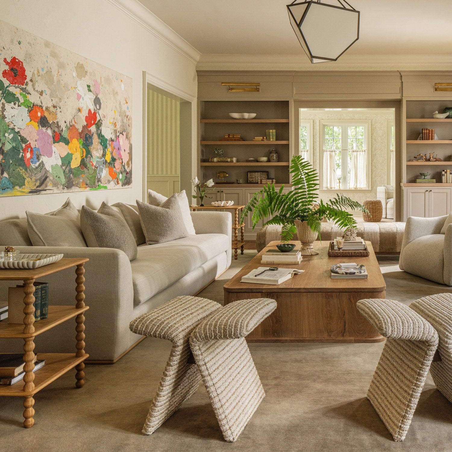 Living room with cream sofas, woven stools, and a large abstract floral painting — Greenway, an interior design project in Coral Gables