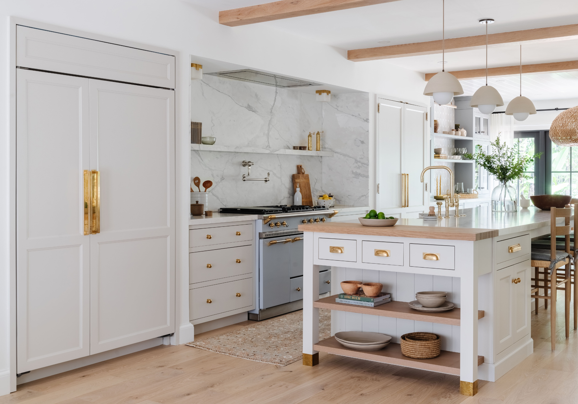 Kitchen design by Calimia Home with white cabinetry, marble backsplash, and a freestanding island