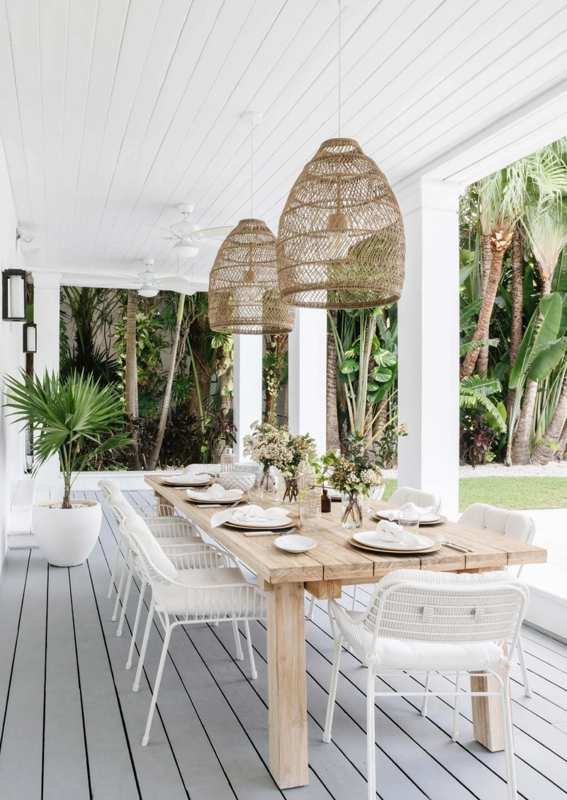 Alfresco dining table with woven pendant trio and white rope chairs at the Sunset Island residence