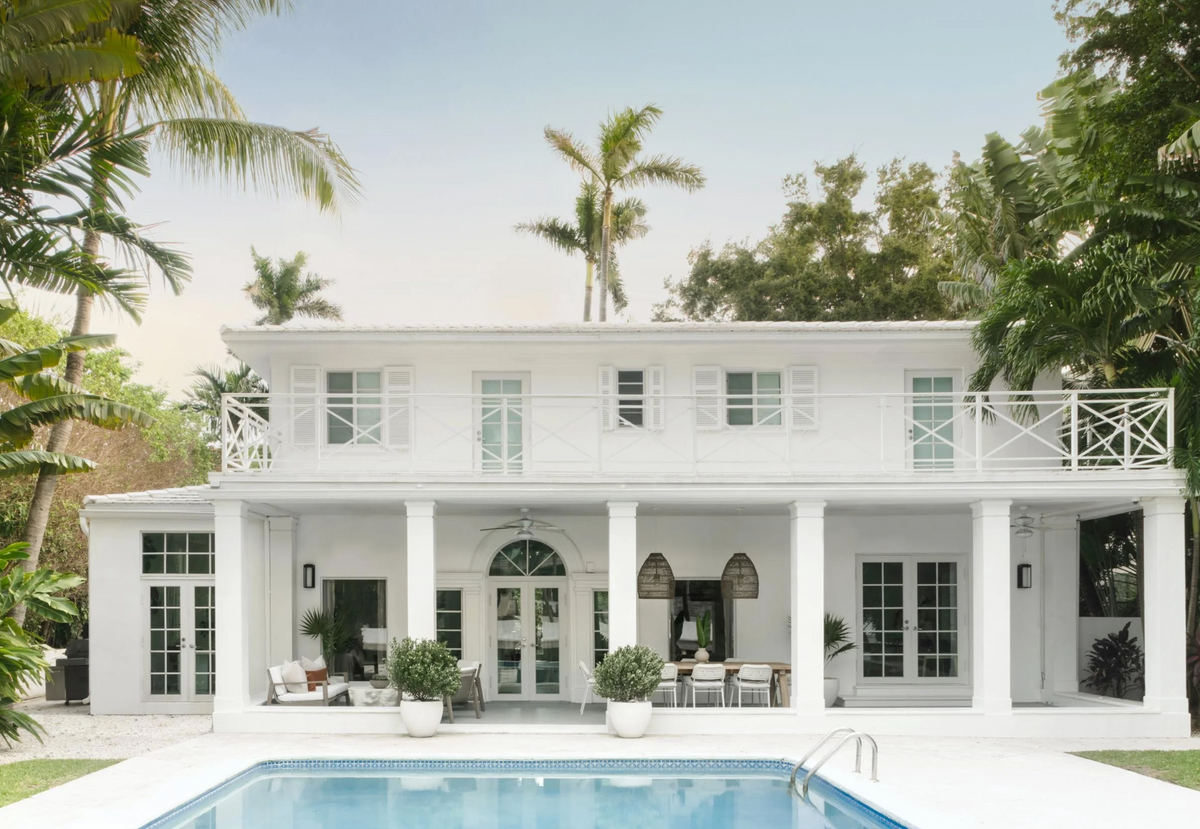 Backyard pool with lounge chairs behind the white Art Deco home on Sunset Island, Miami Beach