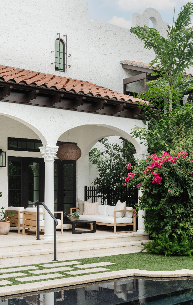 Covered patio with lounge seating and bougainvillea beside the pool, designed by Calimia Home