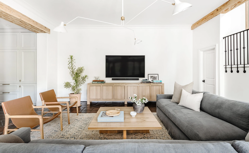 Modern living room with gray sofa, wooden coffee table, and TV stand.