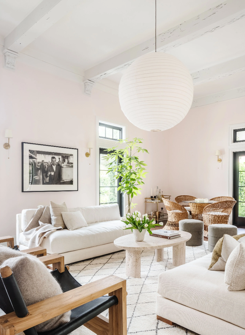 Modern living room with white furniture, wooden accents, and decorative elements.
