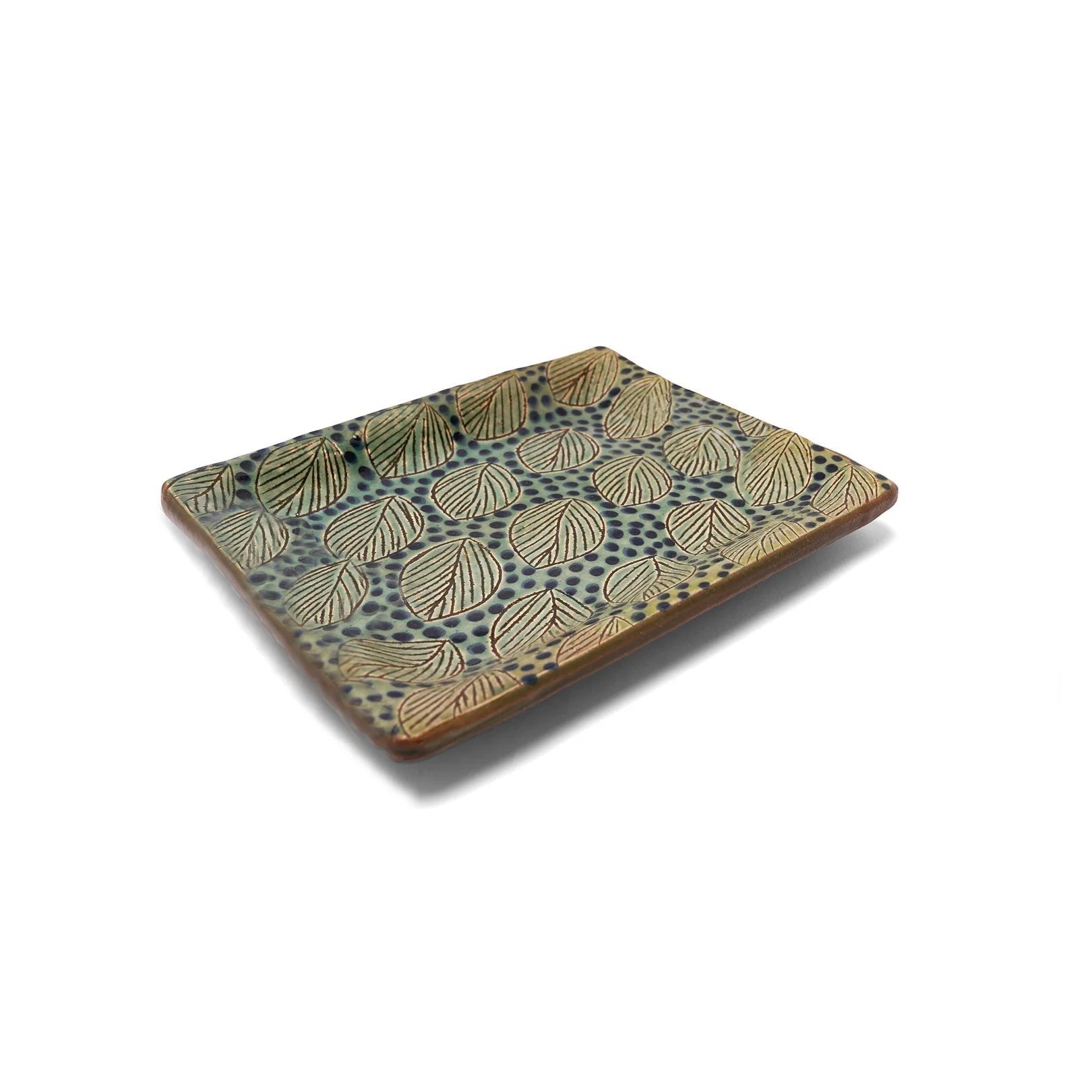 kiliim rectangular ceramic tray with hand-painted green and blue leaf motifs on a textured clay surface.