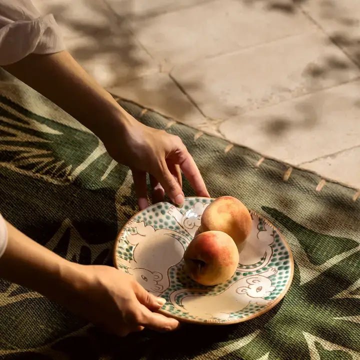 Detail of the hand-painted green cub motif on the Kiliim ceramic serving plate