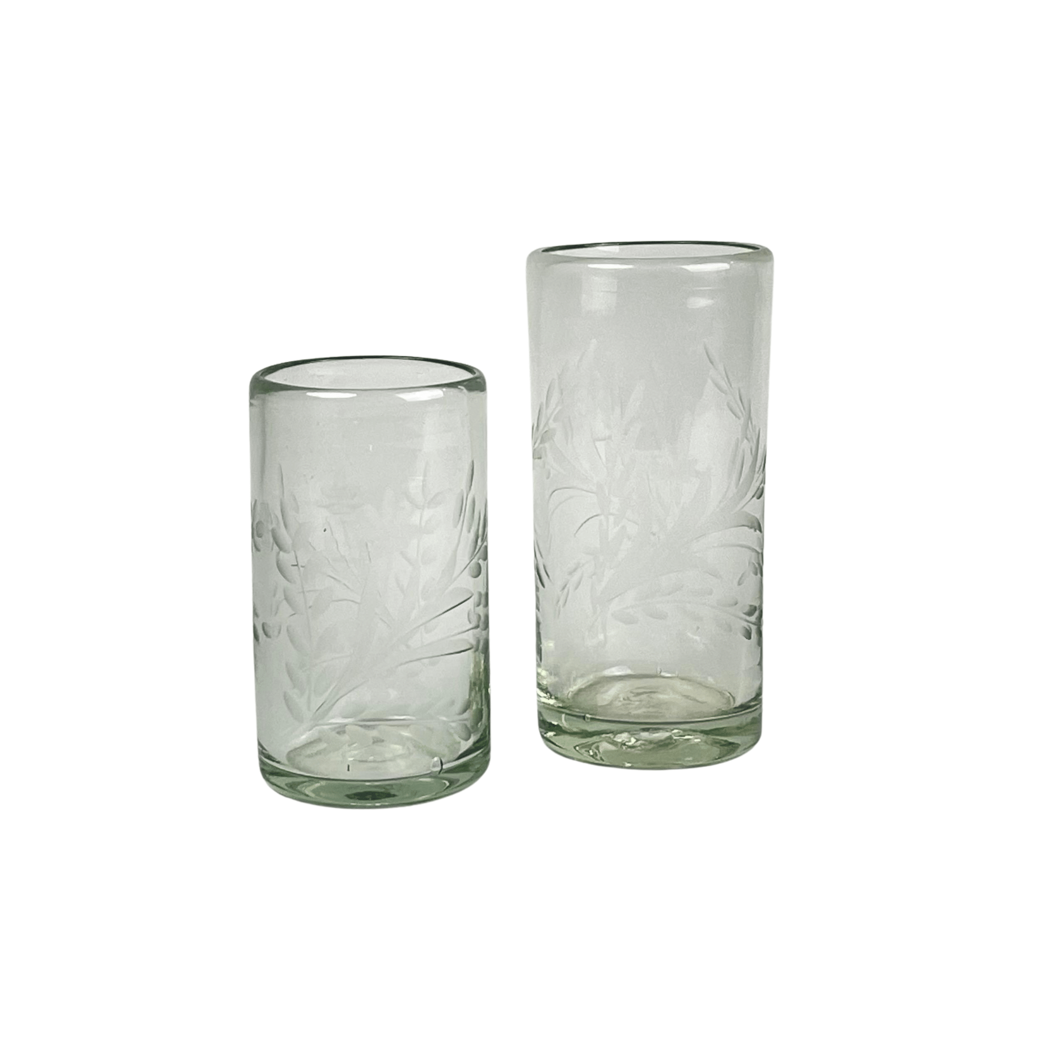 Two Handmade Etched Glass tumblers, one tall and one short, featuring hand-etched leaf designs, are displayed side by side on a white background—showcasing elegant artisanal craftsmanship.