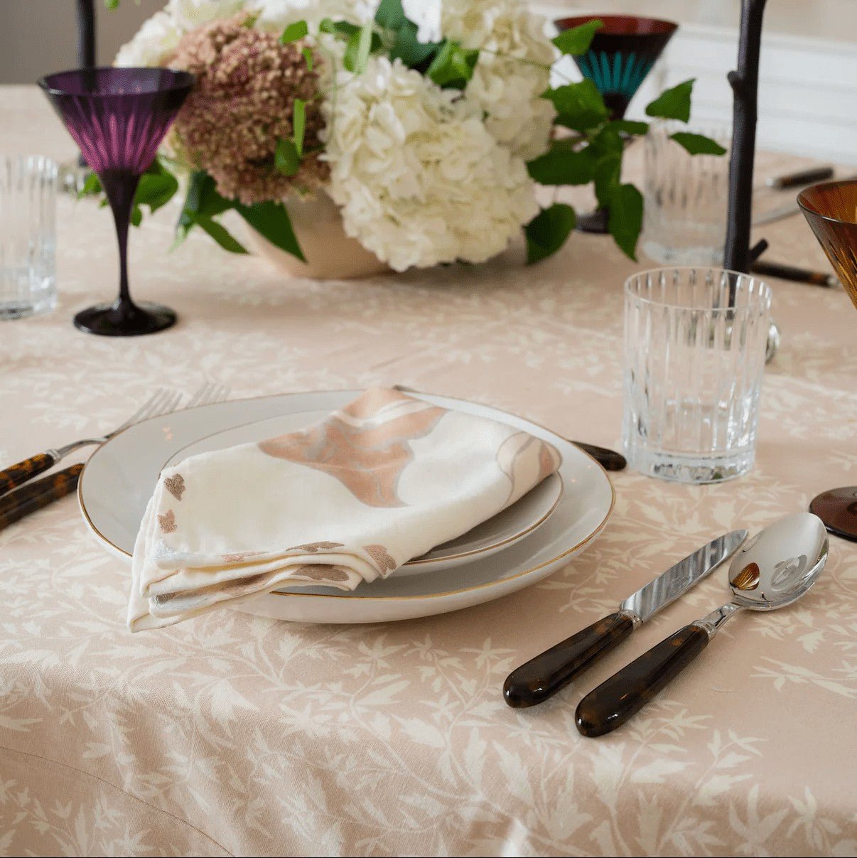 Maison Venu Marguerite Primrose Sand tablecloth with hand block-printed botanical vine motif on a dining table