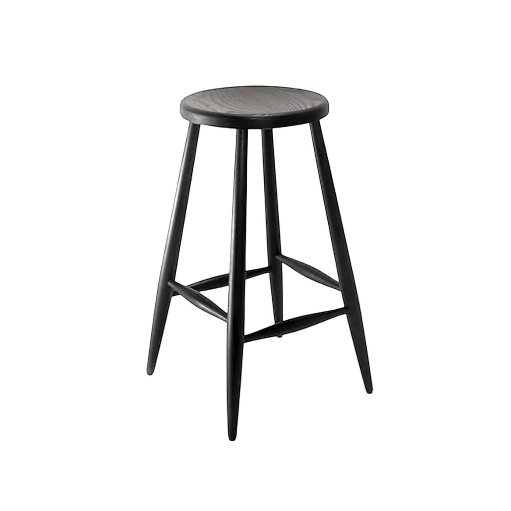 Calimia Home Omah stool in black stained wood with a round seat, tapered legs, and integrated footrests.