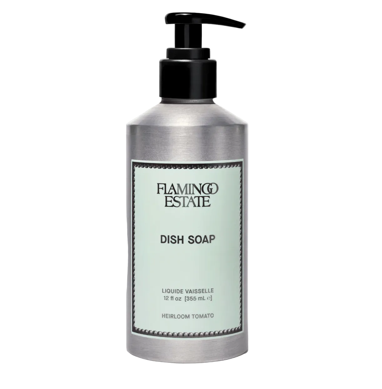 A brushed aluminum Flamingo Estate Heirloom Tomato Dish Soap pump bottle with sage-green label sits centered on a soft cream background.
