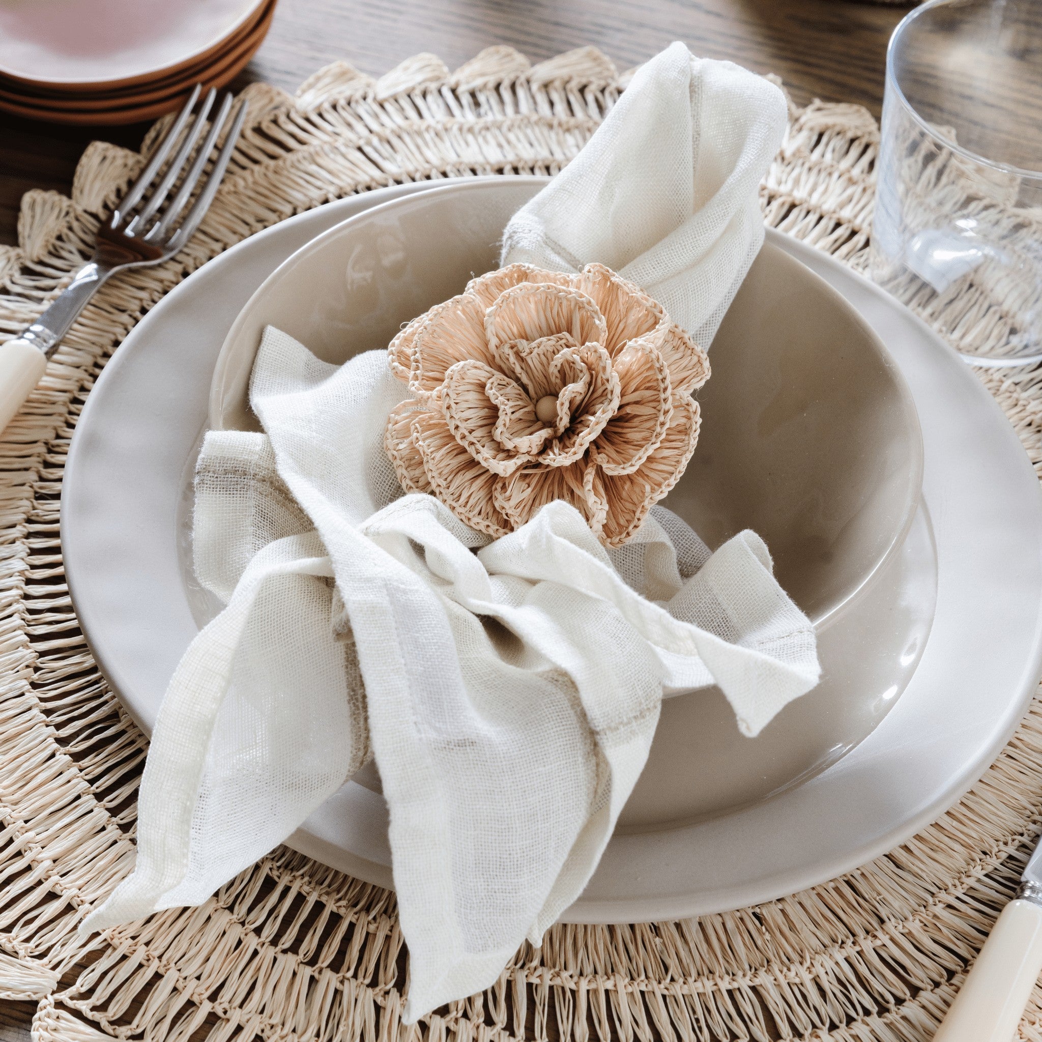 Pom Pom At Home Rutherford natural napkins with stitched stripes and a decorative flower napkin ring on a table setting