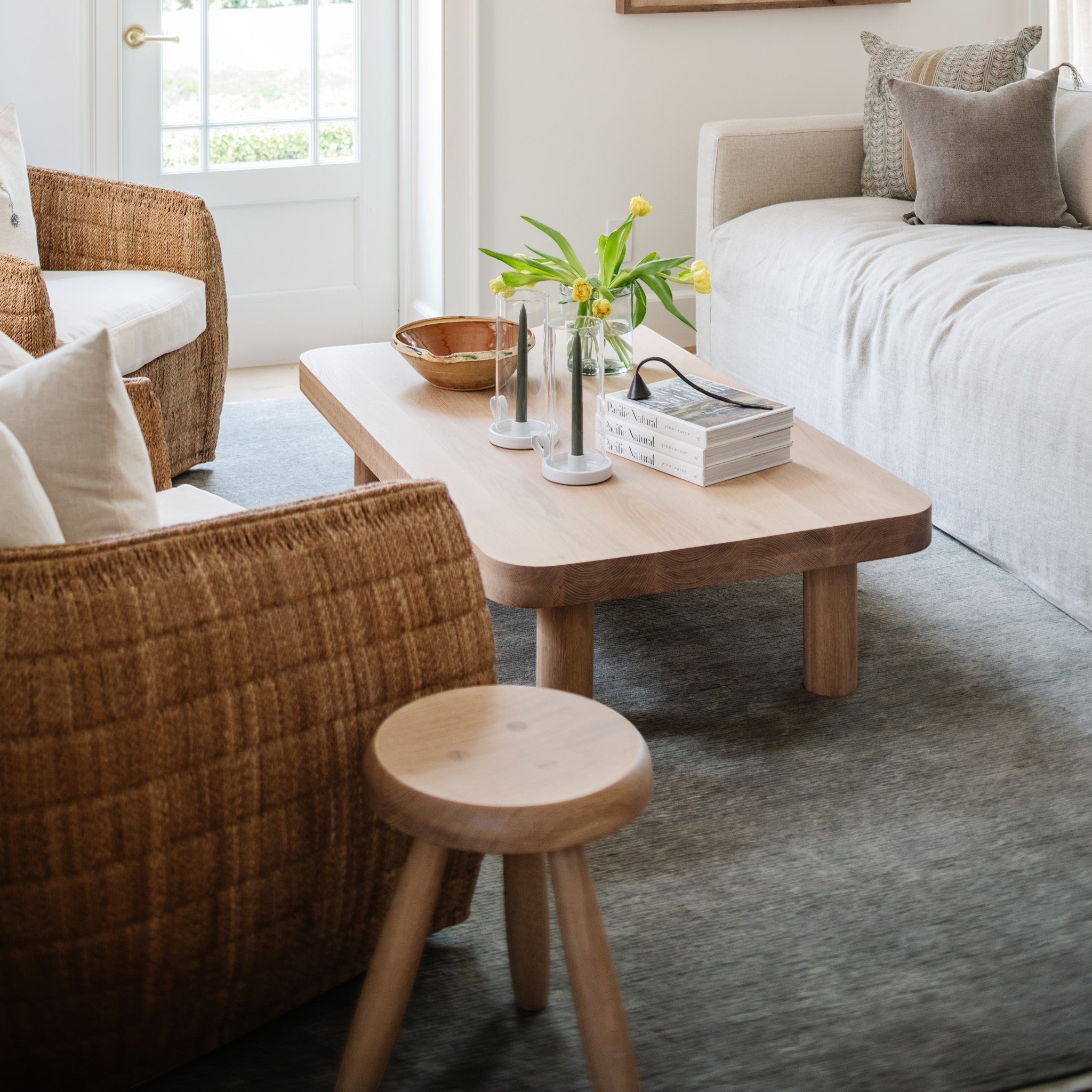 Calimia Home Tori Stool featuring a round wooden top and three tapered legs in a natural hand-rubbed varnish finish.