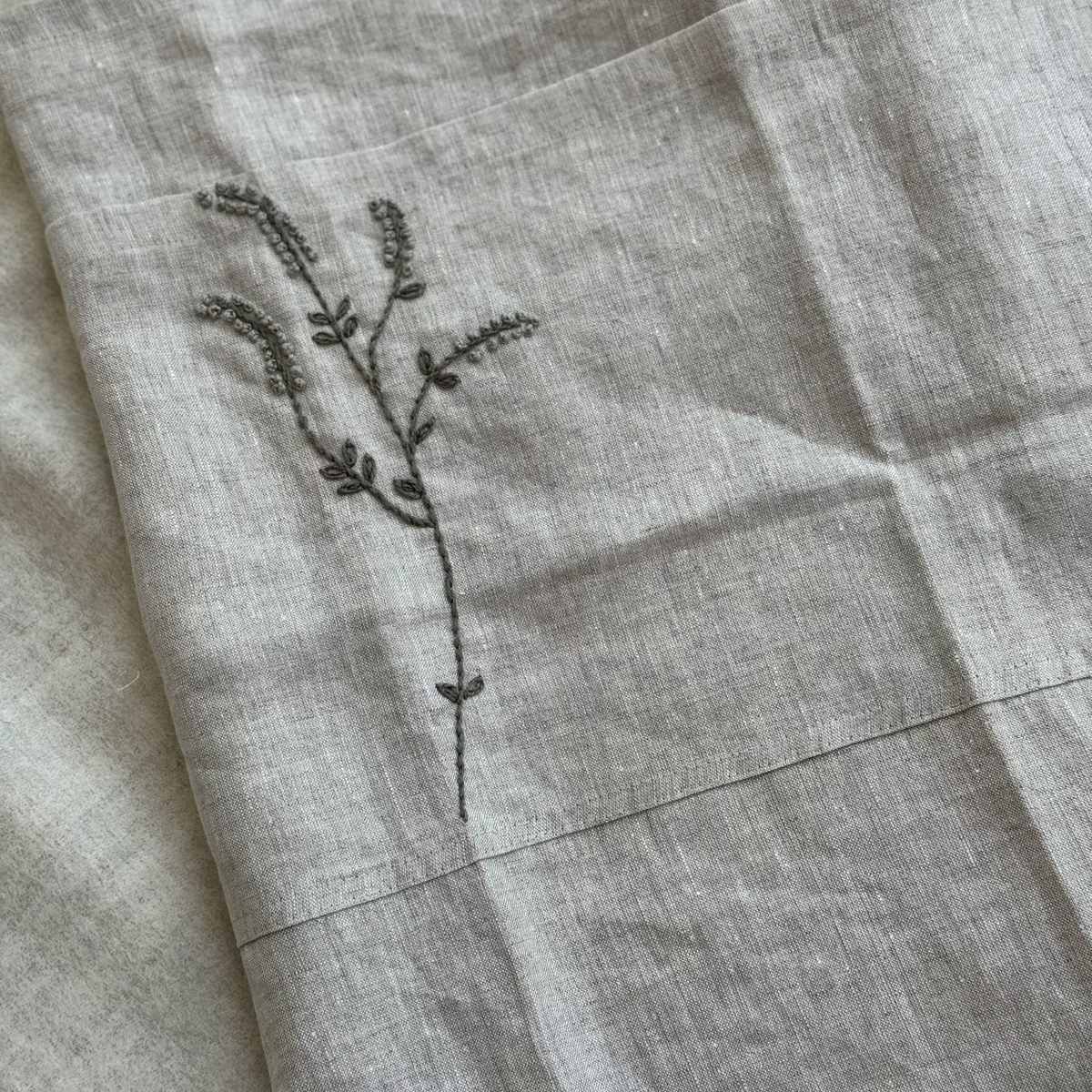 Close-up of the hand-embroidered branch motif on the Willow Stitch Apron, Belgian linen, One Bi One