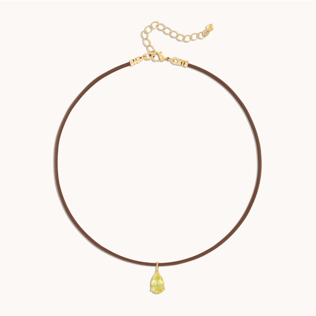 Yellow pear pendant suspended on rubber cord