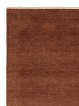 Armadillo Thatch Rug in Copper, corner close-up of the wool pile and edge
