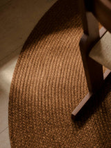 Armadillo Braid Rug in Persimmon, a second view of the hand-braided wool blend rug in a styled interior