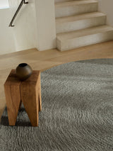 Armadillo Nimbus Rug in Oakmoss, a second view of the hand-braided new zealand wool rug in a styled interior