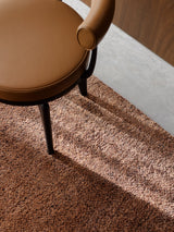 Armadillo Meadow Rug in Brick, a second view of the hand-knotted wool rug in a styled interior