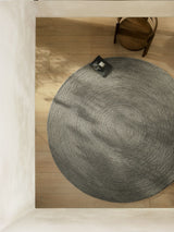 Armadillo Nimbus Rug in Oakmoss, hand-braided new zealand wool rug shown in a room setting