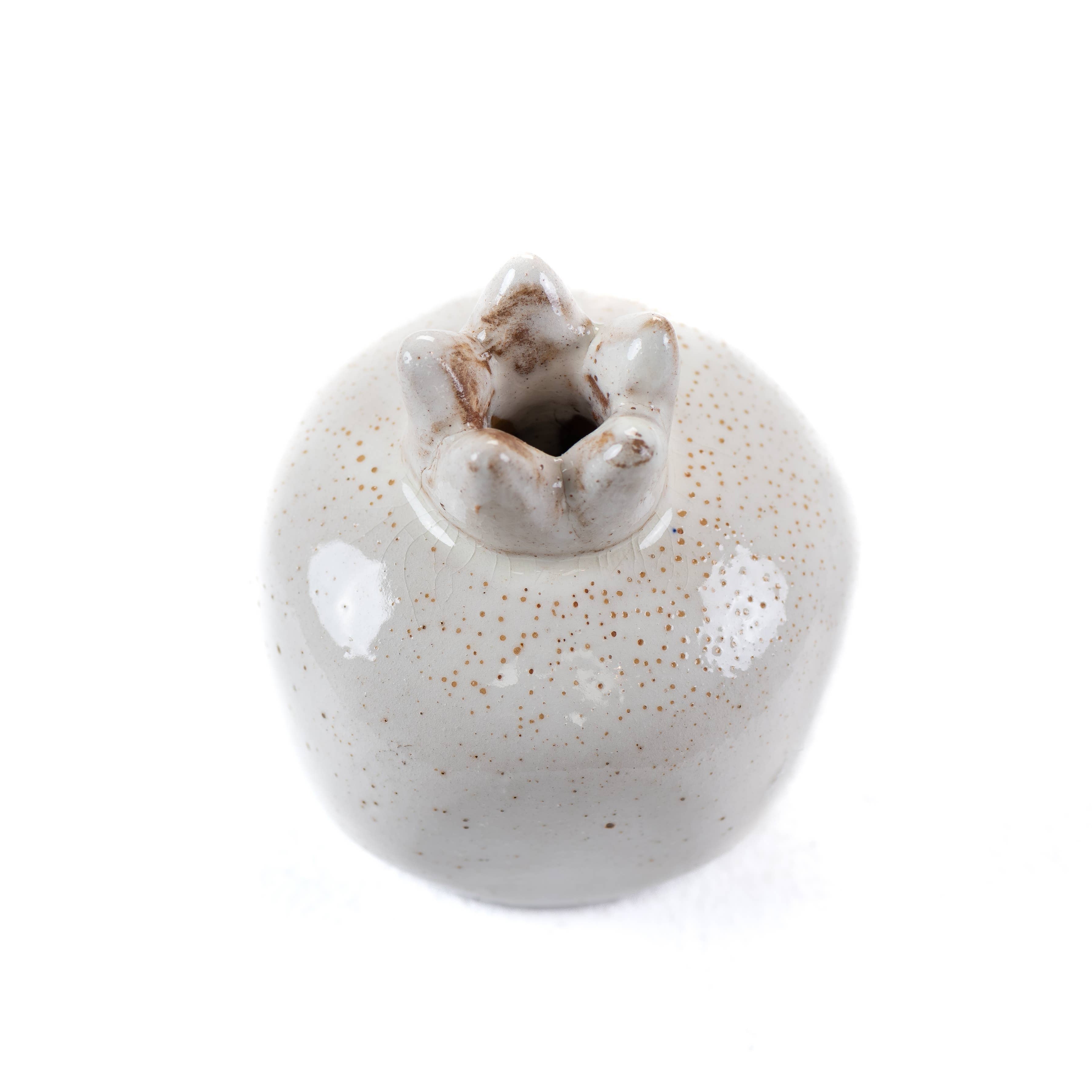 White speckeld ceramic pomegranate vase on a white background