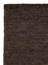 Armadillo Aspen Rug in Peat, corner close-up of the undyed wool pile and edge