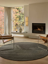 Armadillo Braid Rug in Ivy, hand-braided wool blend rug shown in a room setting