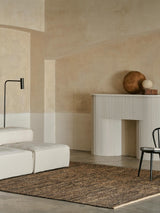 Armadillo Drift Rug in Natural & Black, handwoven jute and wool rug shown in a room setting