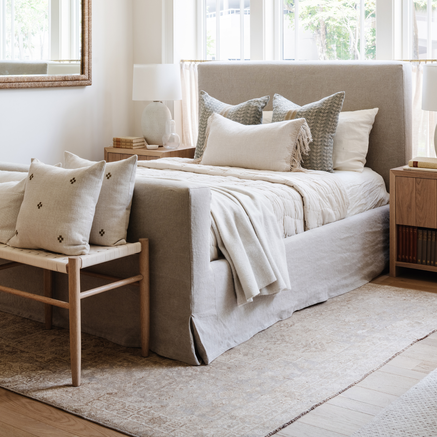 Neatly made bed with decorative pillows in a bright bedroom.