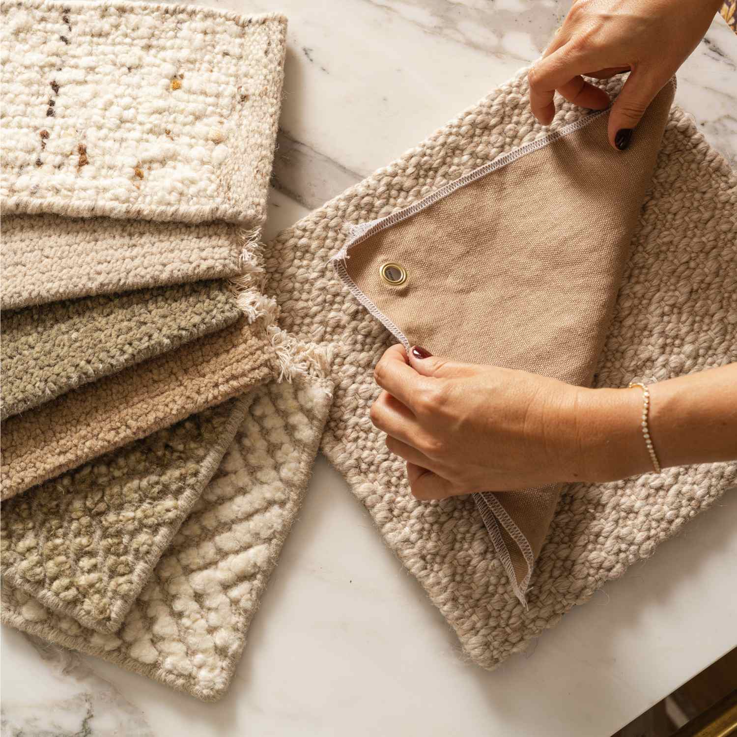 Interior designer comparing wool rug swatches from the Calimia Home trade resource library