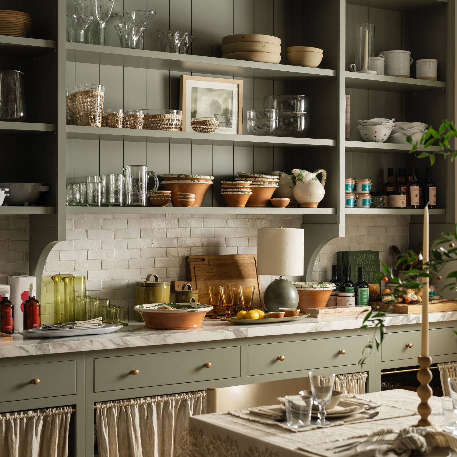 Kitchen vignette at the Calimia Home shop with open shelving, glassware, pottery, and layered tabletop styling.
