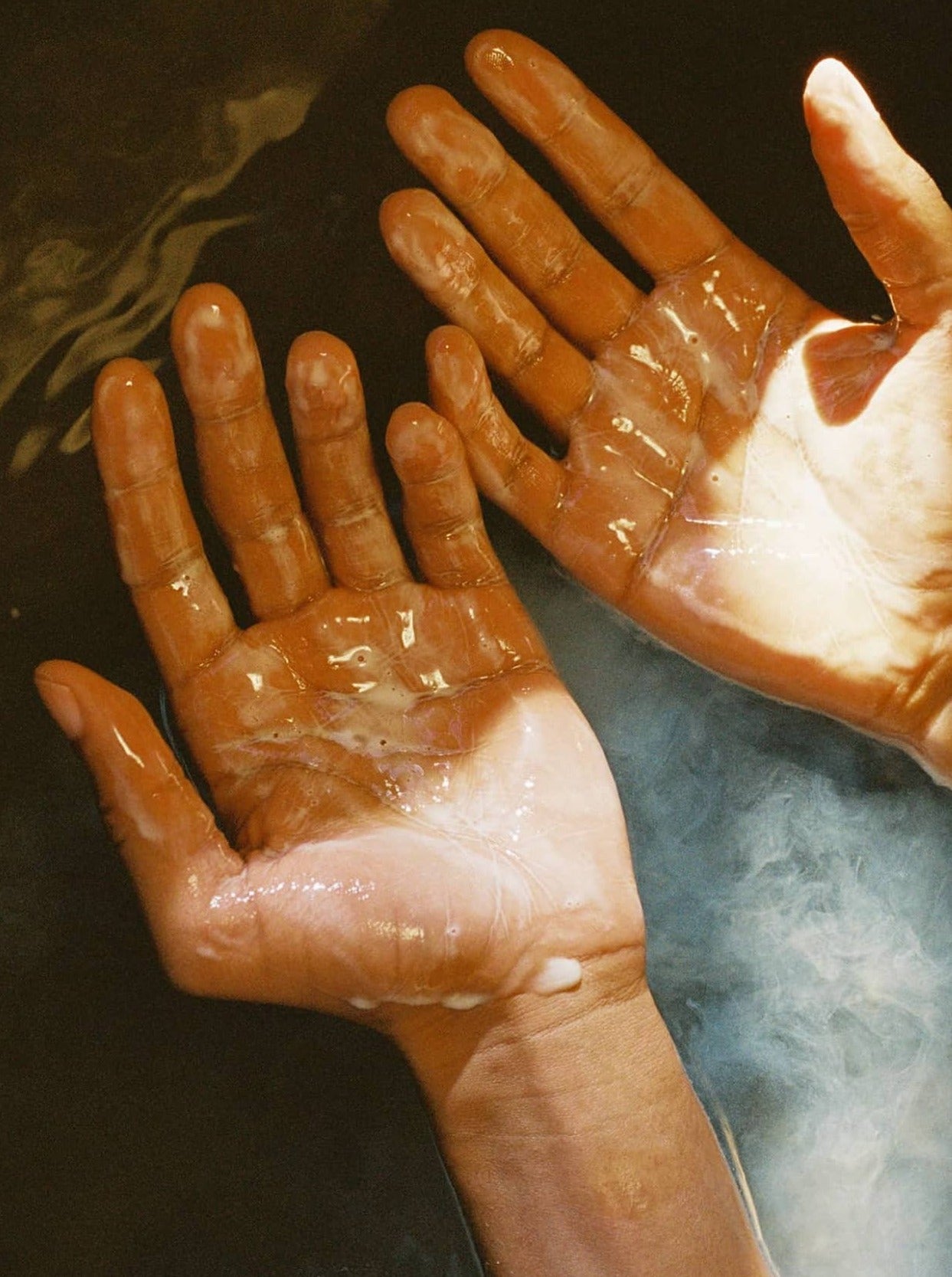 Two wet hands held palms up, lathered in Flamingo Estate Jasmine Damask Rose Castile hand soap.