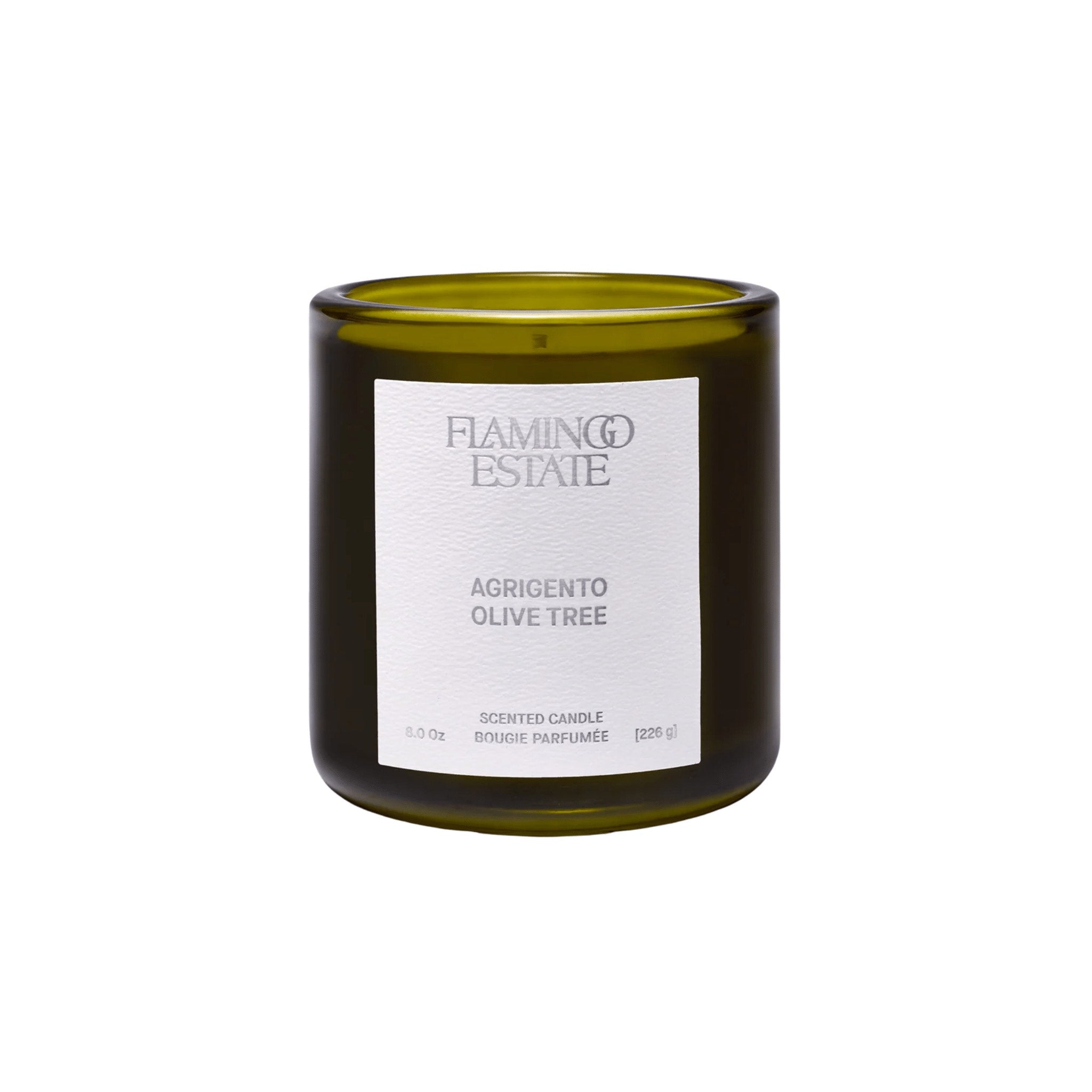 A green glass candle jar with a white label reads Flamingo Estate, Agrigento Olive Tree Scented Candle, 8.0 oz, 226 g. The unlit candle sits on a white background, ready to bring sun-warmed Mediterranean groves indoors.