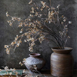 Tall Artificial Hibernal Blossom Soft Blush arrangement by Abigail Ahern beside stoneware vases