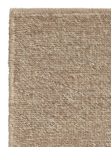 Armadillo Aspen Rug in Sandstorm, corner close-up of the undyed wool pile and edge