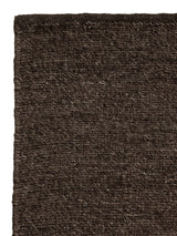 Armadillo Aspen Rug in Peat, corner close-up of the undyed wool pile and edge