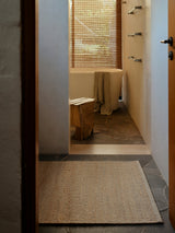 Armadillo Grange Nook Rug in Natural & Sandstone, handwoven wool and jute rug shown in a room setting