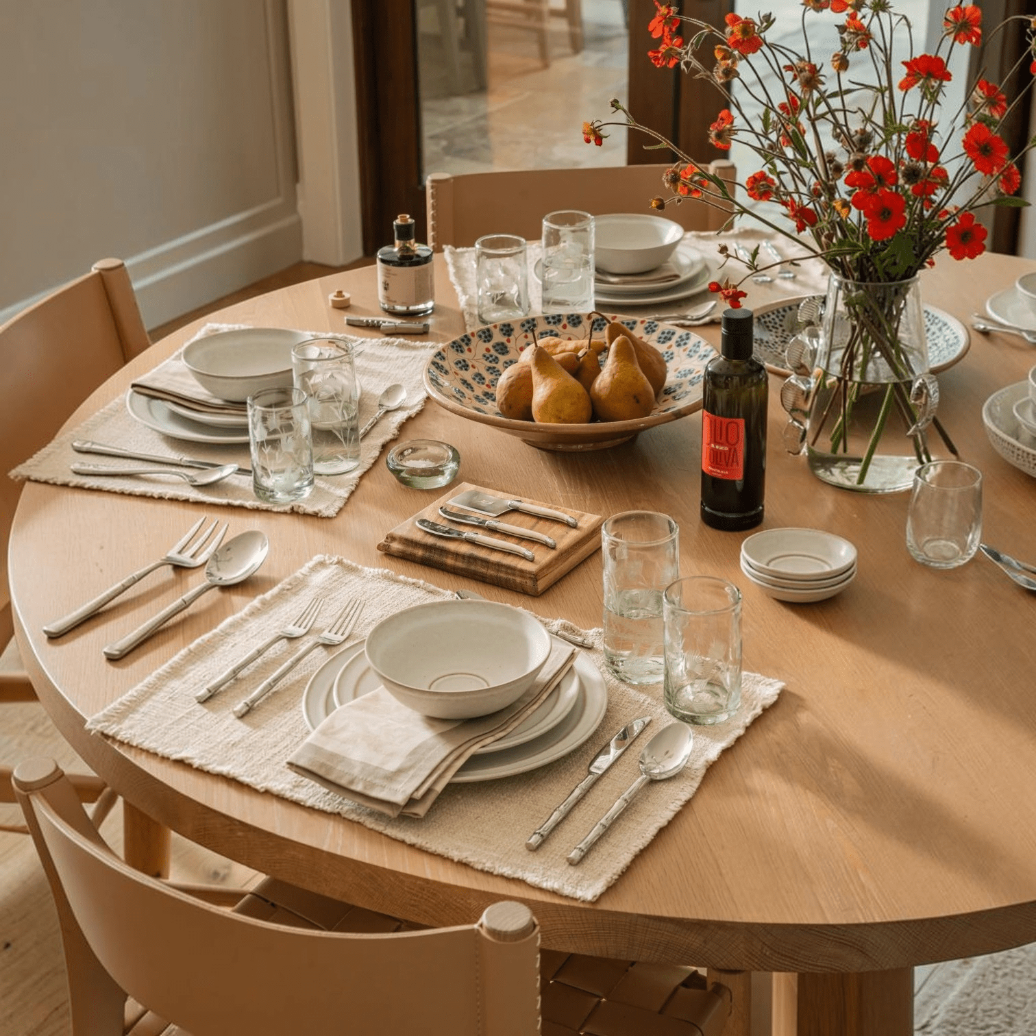 Calimia Home Biancolilla Extra Virgin Olive Oil bottle on a beautifully set wooden dining table with place settings