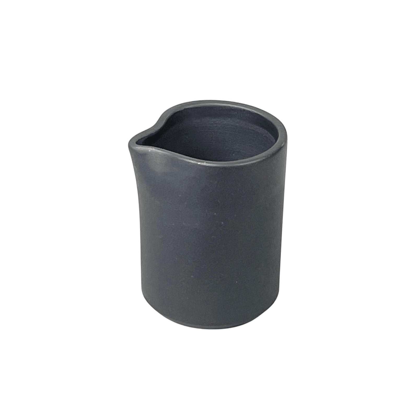 Bitters Co Barro pitcher in matte black clay with a minimalist cylindrical design and a small pouring spout.